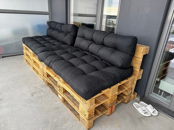 Balkongsoffa av lastpallar med tjocka dynor
