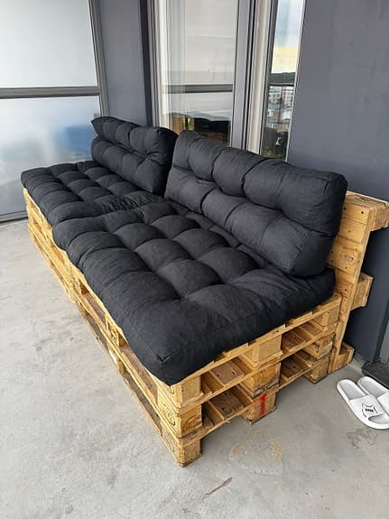 Balkongsoffa av lastpallar med tjocka dynor