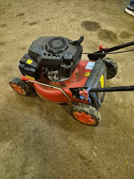 Röd bensindriven gräsklippare