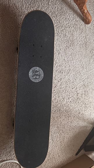 Skateboard med färggrafik och gröna hjul