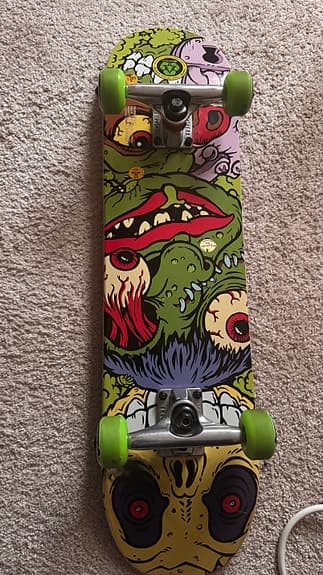 Skateboard med färggrafik och gröna hjul