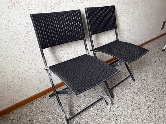 Svarta hopfällbara stolar i konstrotting