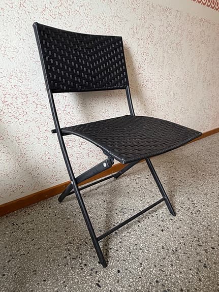 Svarta hopfällbara stolar i konstrotting