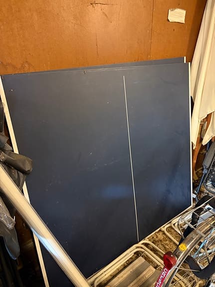 Bordtennisbord med nät och flera racketar