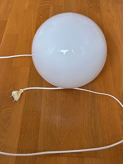 Vit rund lampa med sladd som ger mycket ljus i mörka hörn