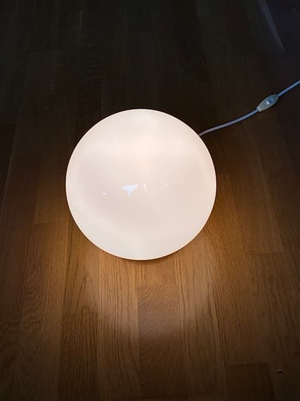Vit rund lampa med sladd som ger mycket ljus i mörka hörn
