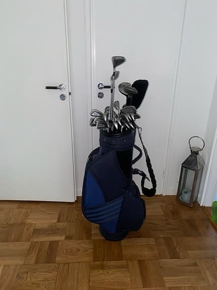 Golfklubbor med bag och golfvagn