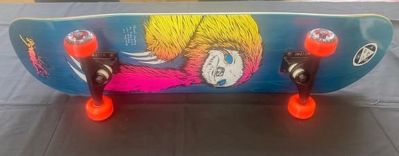Skateboard med färggrafik och orange hjul