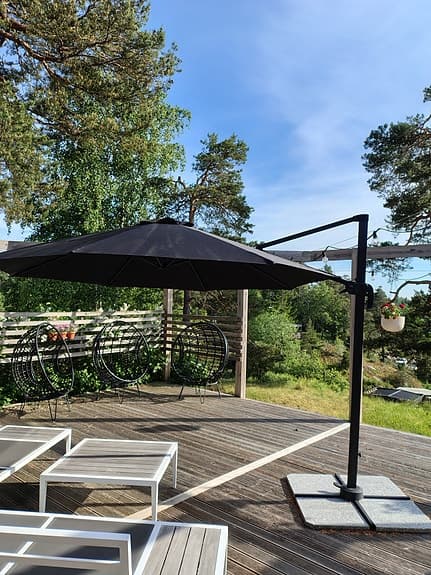 Svart hängparasolll på fot till altan/uteplats