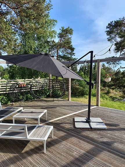 Svart hängparasolll på fot till altan/uteplats
