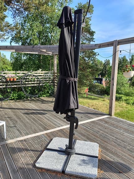 Svart hängparasolll på fot till altan/uteplats