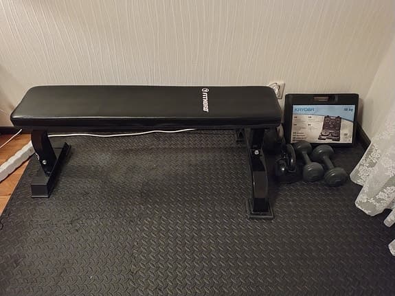 Träningsbänk med matta, hantelset och kettlebells