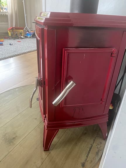 Röd kamin med glaslucka