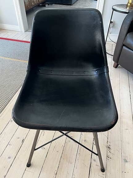 Annonsrubrik: Designstol i svart läder från Nordiska Hem – Industriell stil