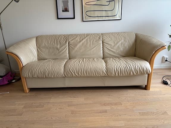 Beige 3-sits skinnsoffa med detaljer i ljus bok