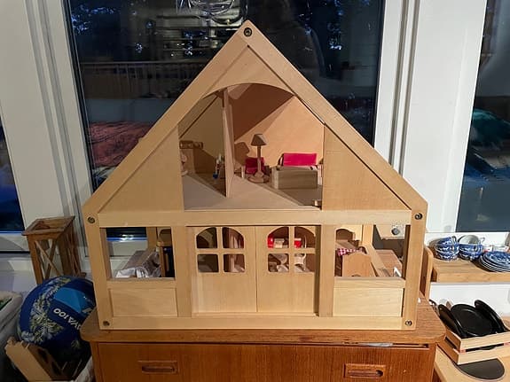 Trähus dockskåp med  skjutdörrar och möbler och dockor. Plan Toys