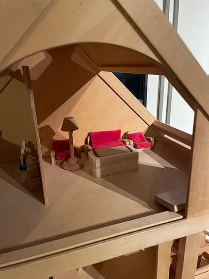 Trähus dockskåp med  skjutdörrar och möbler och dockor. Plan Toys