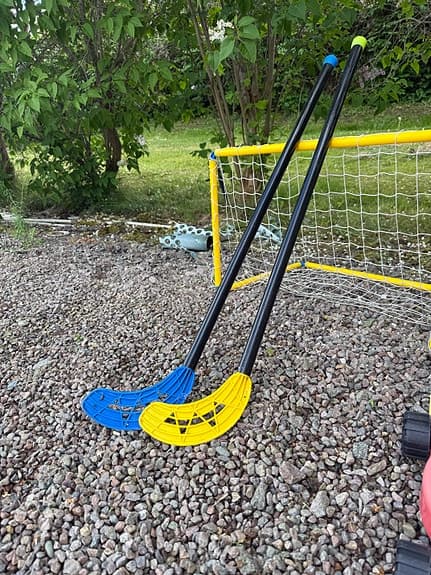 Bandymål med 2 klubbor, gräsklippare och ett plastgolfsätt