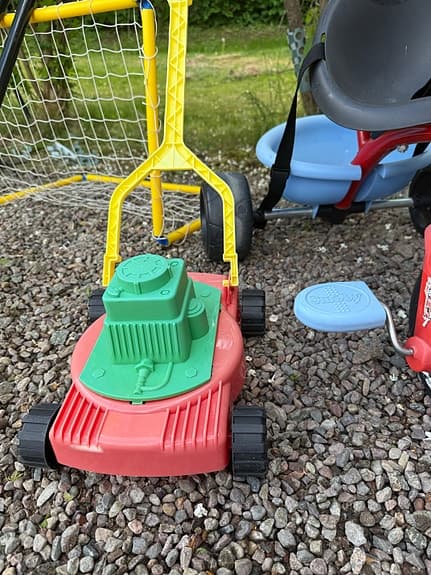Bandymål med 2 klubbor, gräsklippare och ett plastgolfsätt