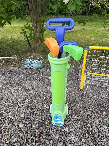 Bandymål med 2 klubbor, gräsklippare och ett plastgolfsätt