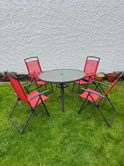 Runt trädgårdsbord med 4 röda stolar