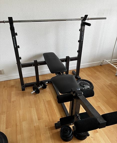 Träningsbänk med skivstång och vikter