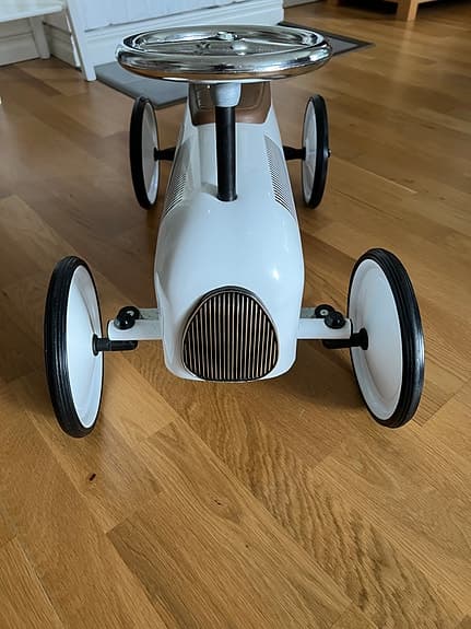 Vit gåbil i retrostil som stått som inredningsdetalj