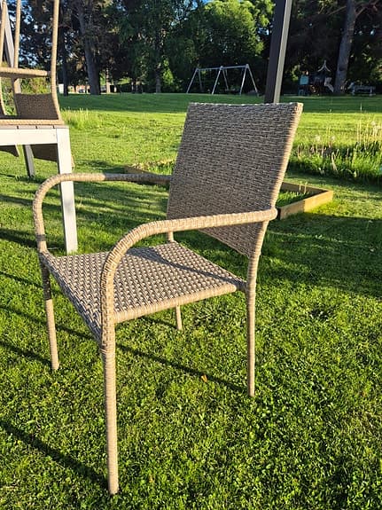 Beige trädgårdsstol i konstrotting med armstöd