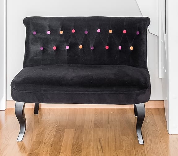 Elegant hallsoffa från Åhléns – svart sammet med färgglada knappar