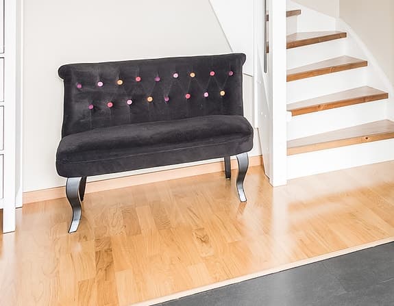 Elegant hallsoffa från Åhléns – svart sammet med färgglada knappar
