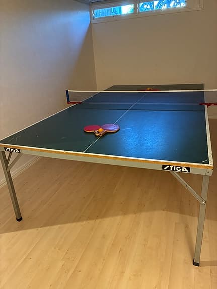 Bordtennisbord med nät, racketar och bollar