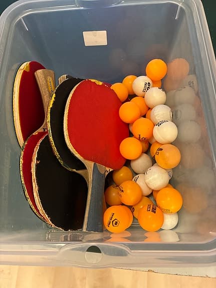 Bordtennisbord med nät, racketar och bollar