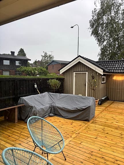 Hörnsoffa i konstrotting med vita dynor för uteplats
