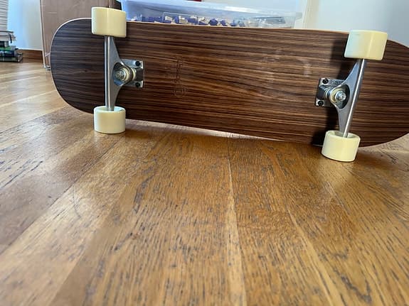 Skateboard med träbräda och vita hjul