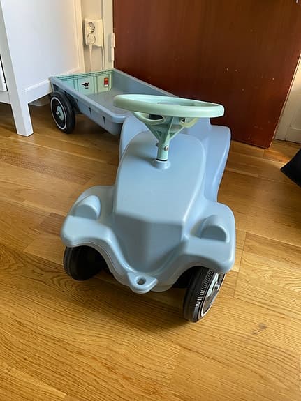 Blå Bobby car liknande gåbil med släp