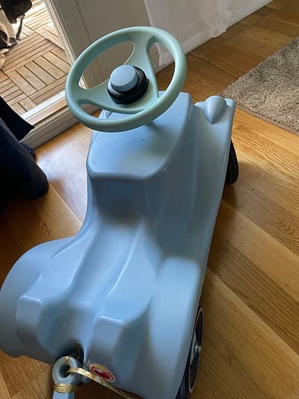 Blå Bobby car liknande gåbil med släp