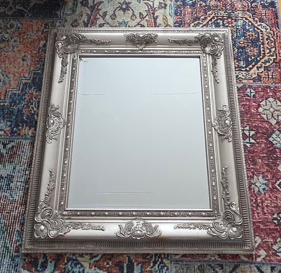 Stor vacker spegel med dekorerad ram och fasettslipat glas. 75 × 85 cm.