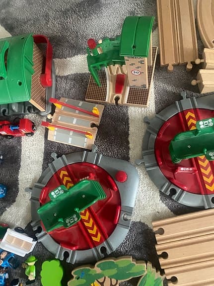 BRIO tågbana med flera lok, vagnar och stationsbyggnader.