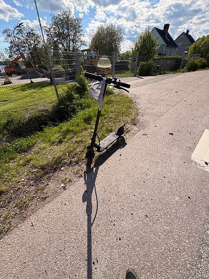 Svart elsparkcykel med display och handbroms
