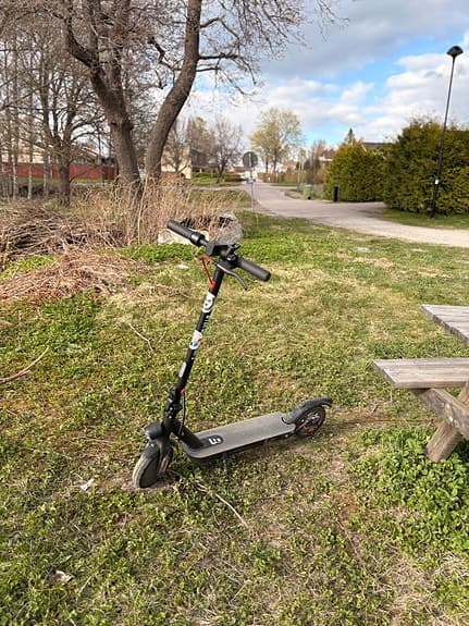 Svart elsparkcykel med display och handbroms
