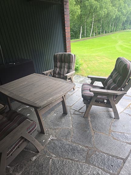 Trädgårdsgrupp med stort bord och fåtöljer i trä