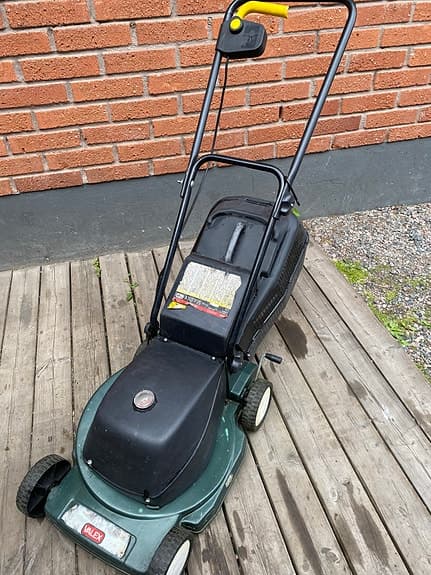 Grön elgräsklippare med uppsamlare