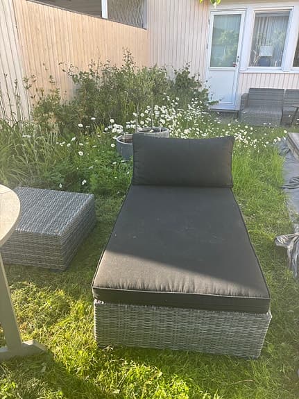 Grå konstrotting solsäng med dyna och fotpall