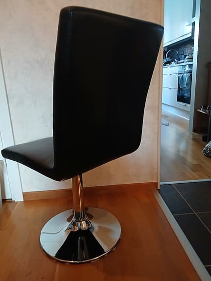 Svarta stolar med hög rygg i konstskinn