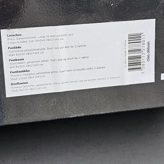 Svart postlåda med lock och lås