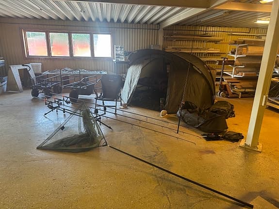 Karpfiskeutrustning med tält, säng och vagnar