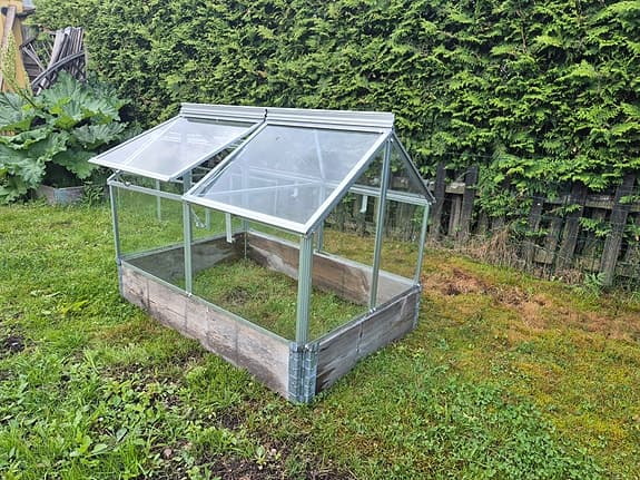 Litet växthus i glas. 2 pallkragar ingår.