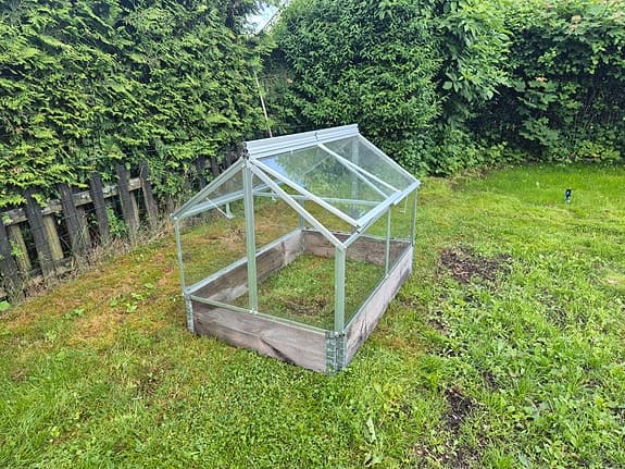 Litet växthus i glas. 2 pallkragar ingår.