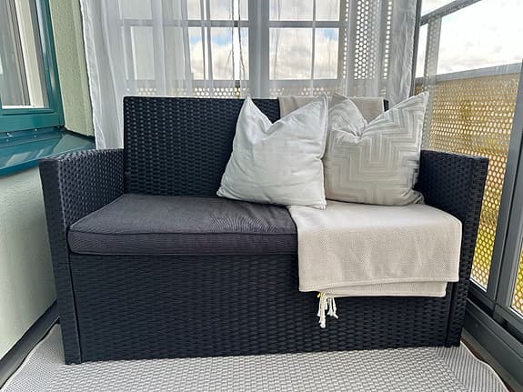 Ute-och balkongmöbler. Svart konstrotting soffa och fåtölj med grå dynor