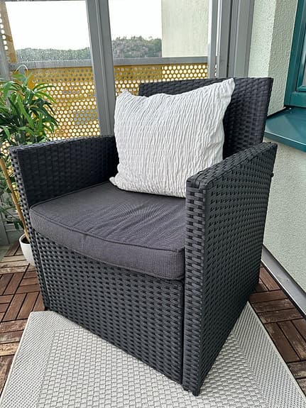 Ute-och balkongmöbler. Svart konstrotting soffa och fåtölj med grå dynor